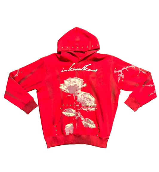 Red hoodie with a rose design and 'inkwellens' branding on a green grass background