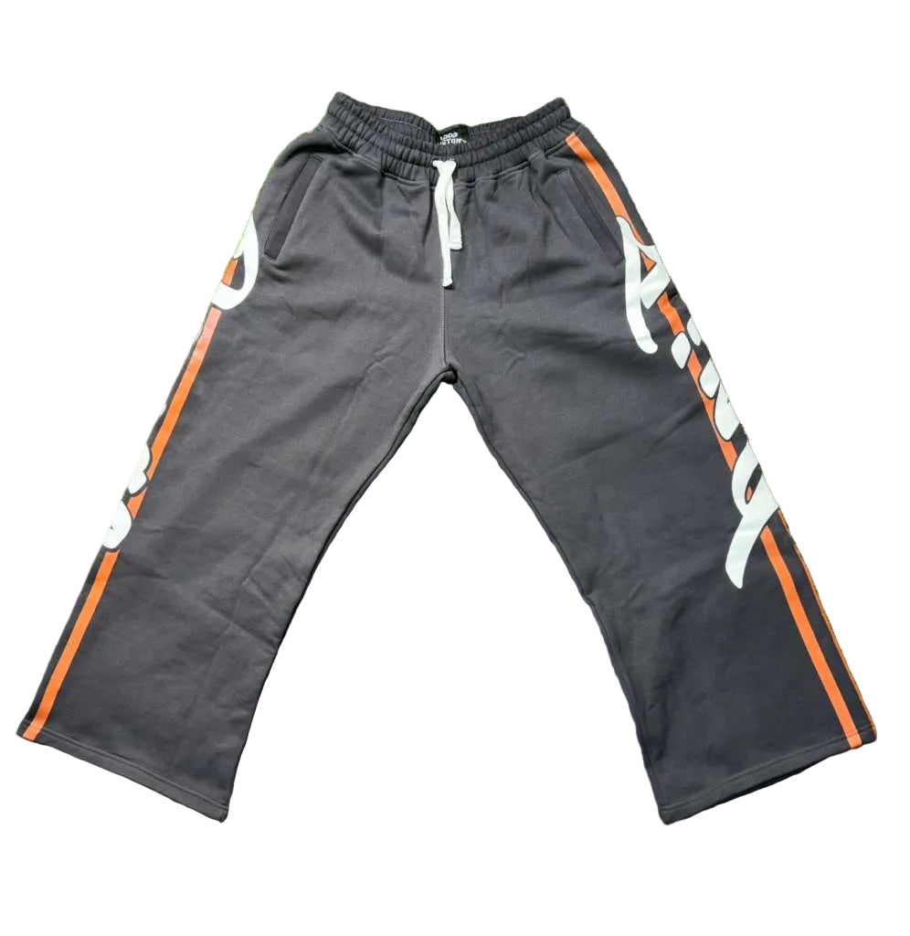 Gray sweatpants with orange and white accents on a green grass background
